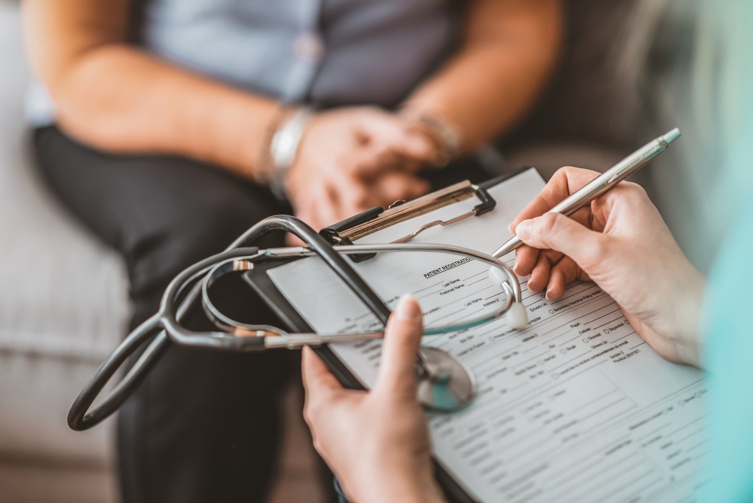 Woman Having Health Check With Nurse At Home